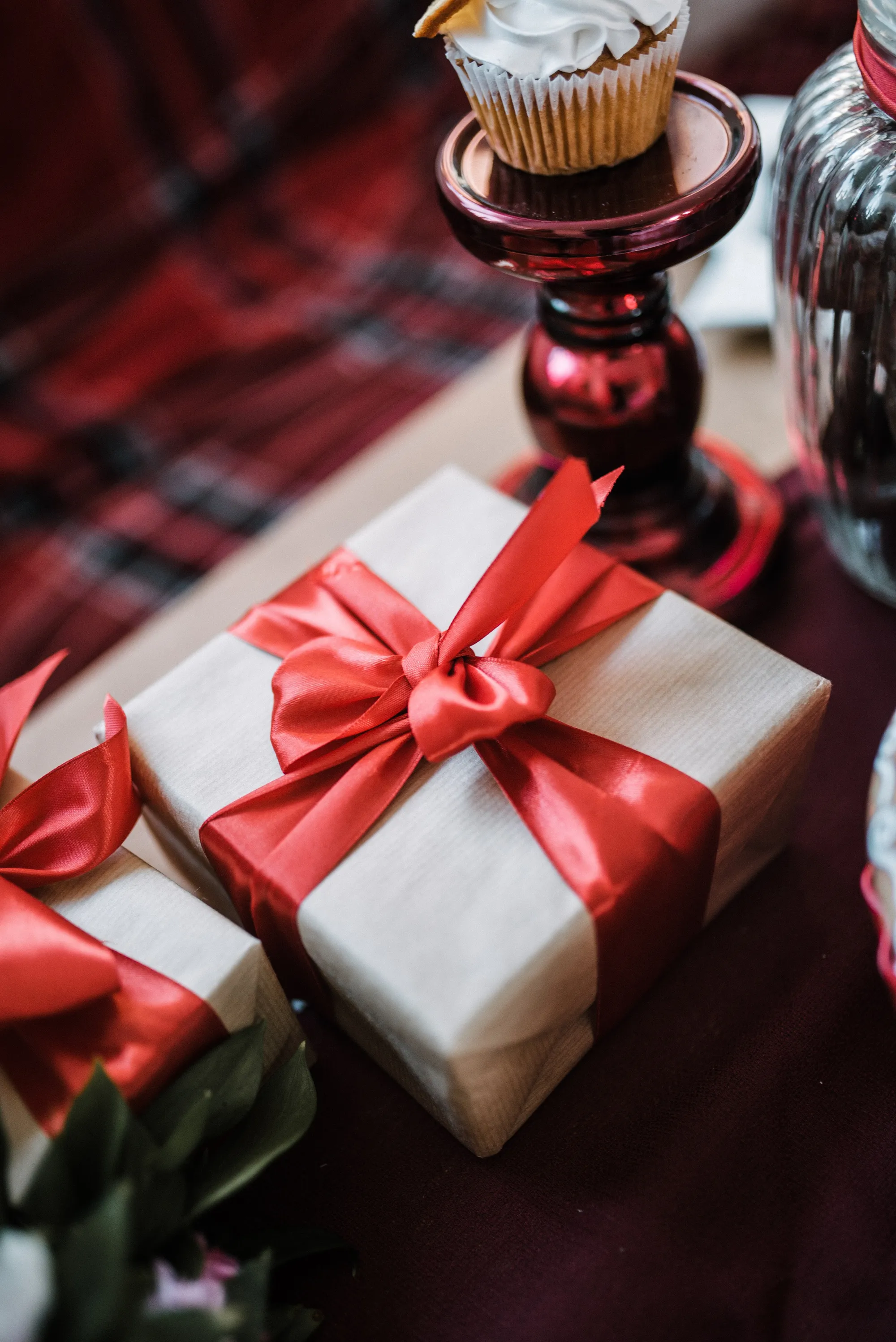 A brown paper gift box tied with a red ribbon and bow.