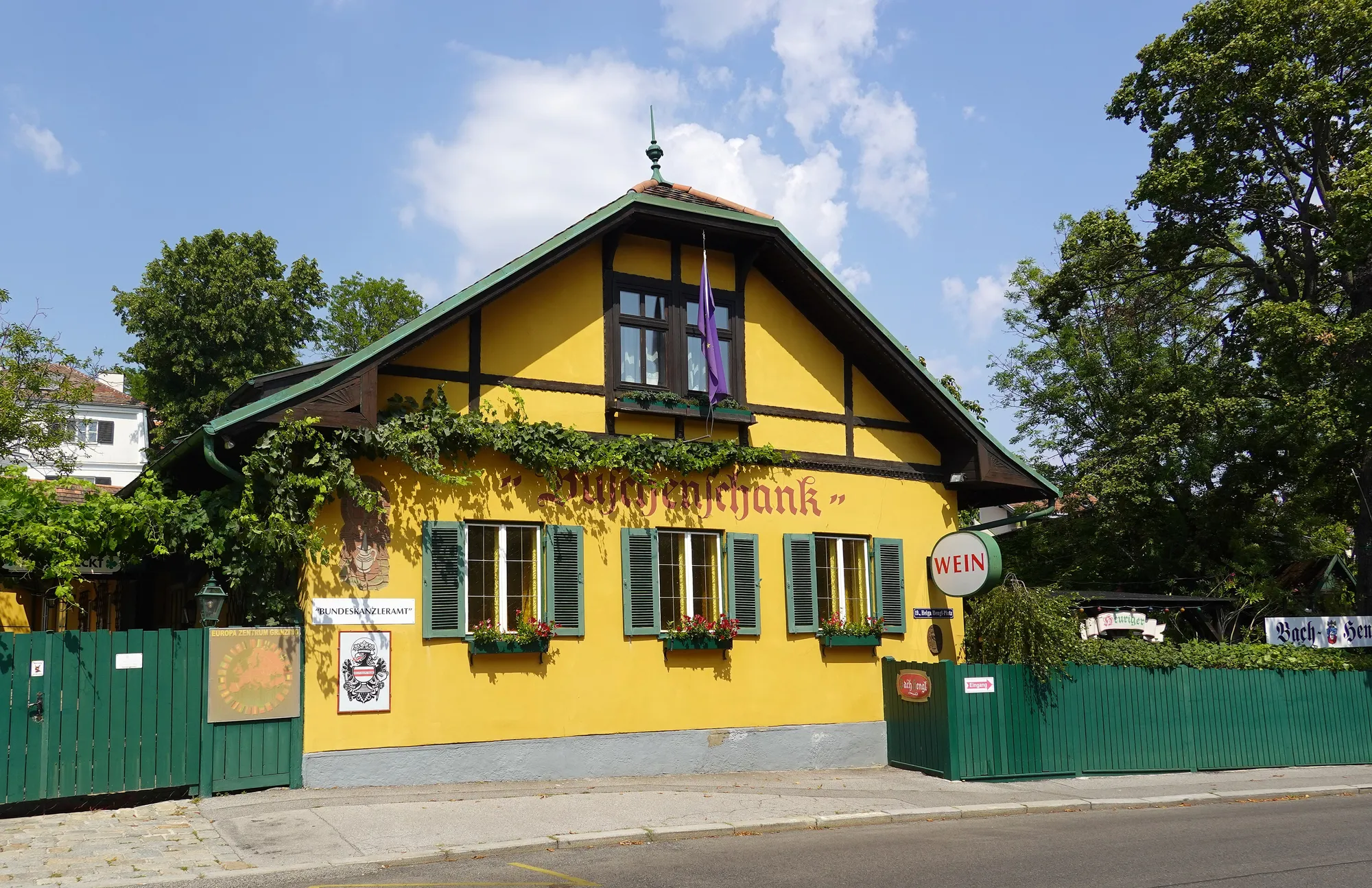 A Heuriger in Grinzing: the vine-hung courtyard with its wooden benches set for the evening.