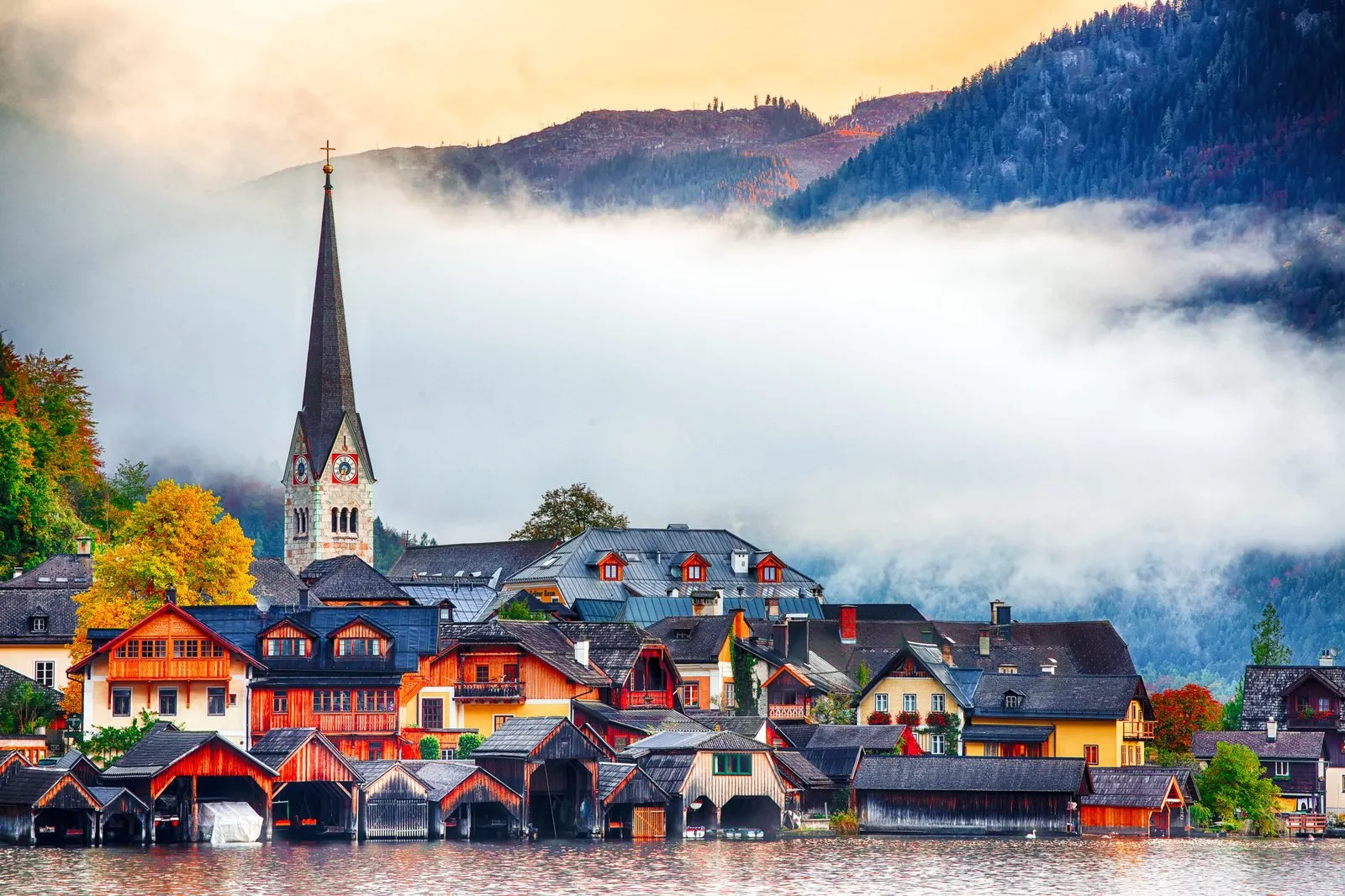 Hallstatt village and its church tower against the mountain, seen along the lakeshore