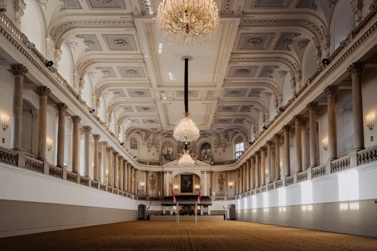 The empty Winter Riding School: white columns, a chandelier, the gallery