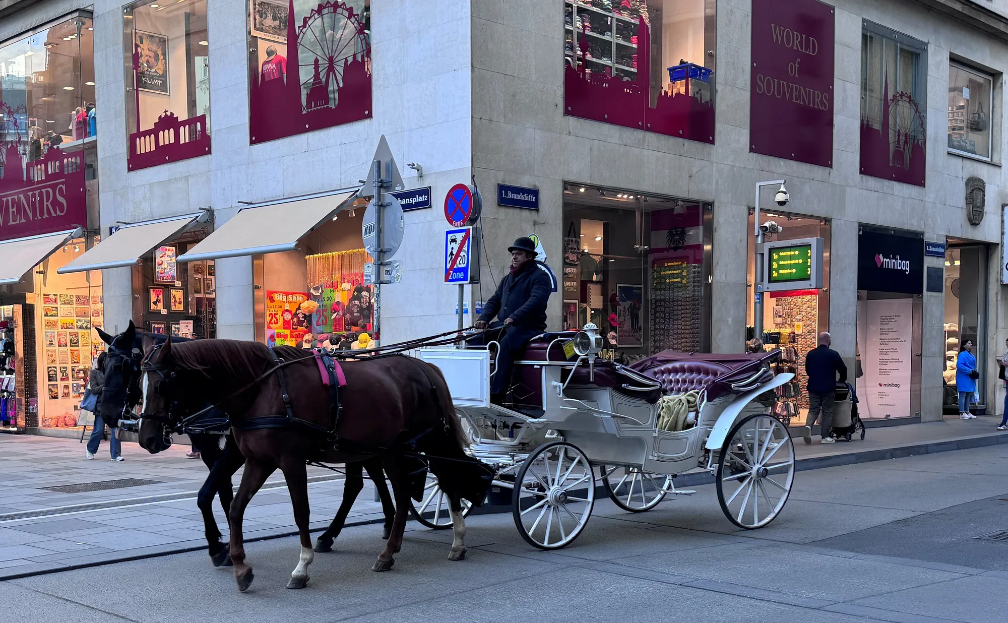 A Fiaker with two dark horses turning off Stephansplatz into the Graben.