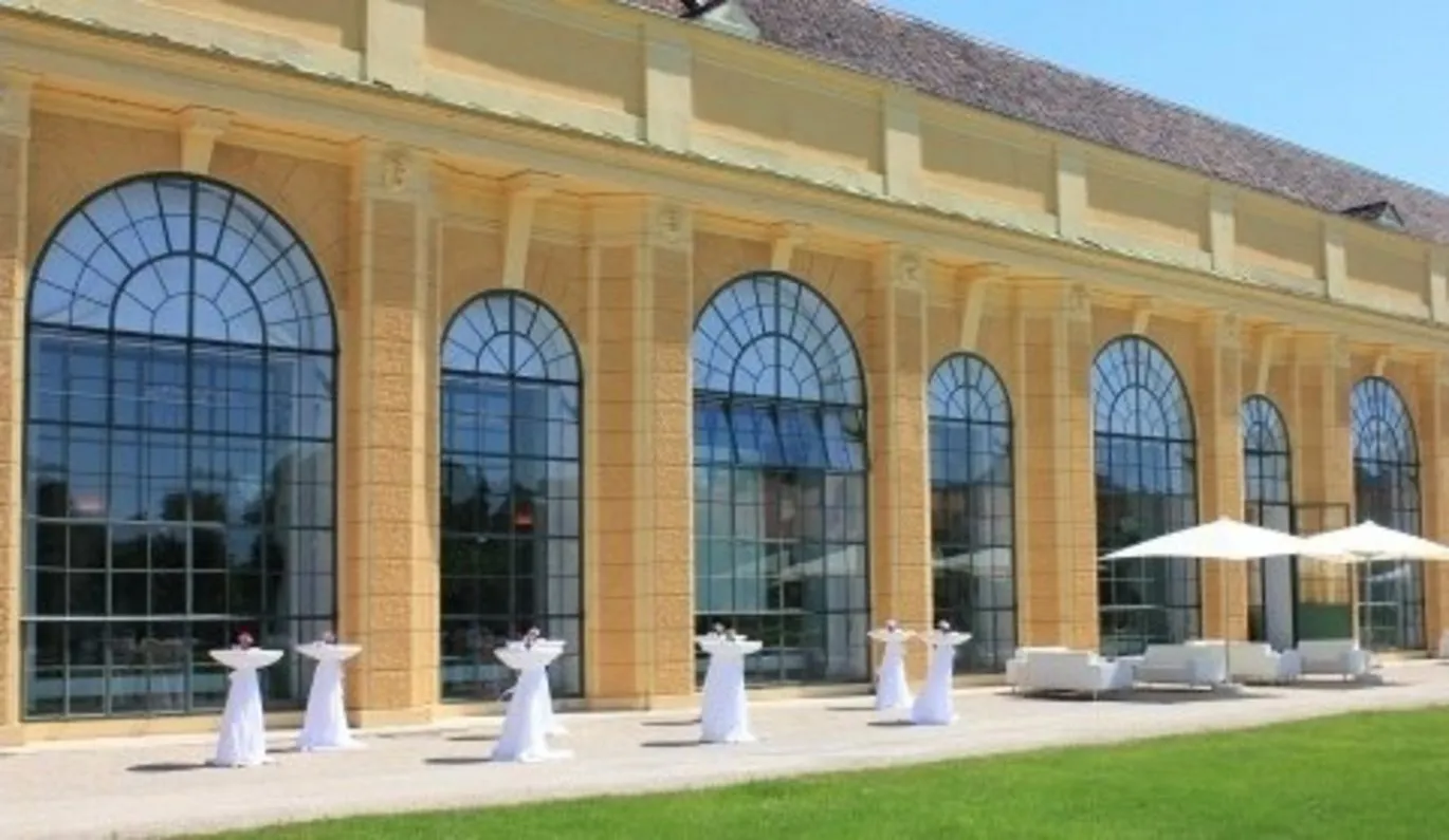 The south front of the Orangery by day: the long row of round-arched windows and the rusticated pilasters between them.