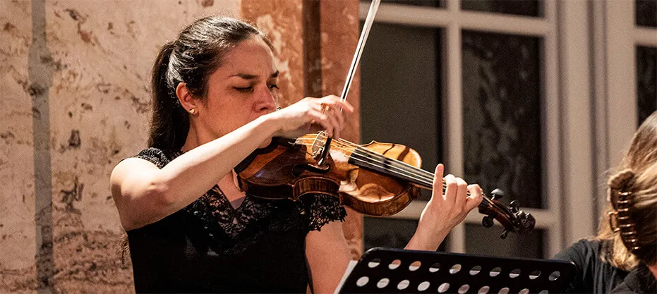 A violinist of the ensemble playing a Baroque violin.