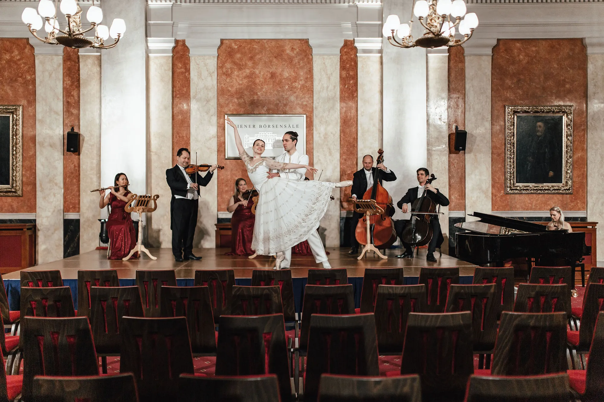 A dancing pair on the podium of the Festsaal of the Palais alte Börse, the ensemble playing behind them.